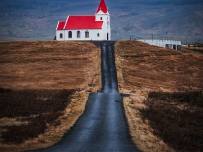 white and red concrete building near body of water during daytime